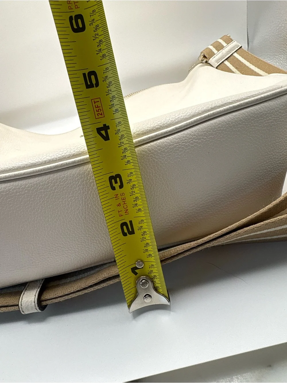 Kate Spade New York cream leather crossbody bag featuring a striped webbing Stra